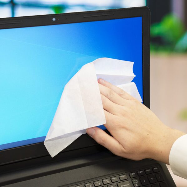 Eine Person wischt den Bildschirm eines Laptops mit Anti-bac+ Desinfektions- und antibakteriellen Bildschirmreinigungstüchern ab – x60 BSCRW60T.
