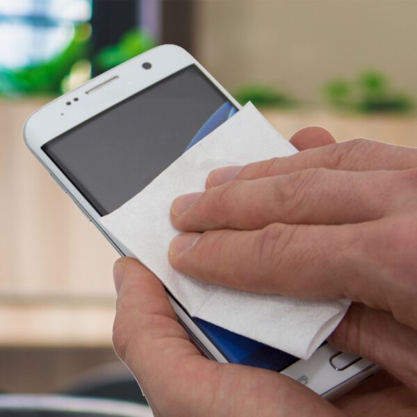 Eine Person wischt ein Mobiltelefon mit antibakteriellen Anti-Bac+-Bildschirmreinigungstüchern ab.