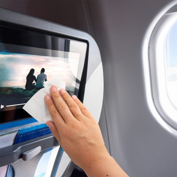 A person is wiping a screen on an airplane with the Anti-bac+ Sanitising Antibacterial Screen & Multipurpose Wipes - x25 ABTW025P.