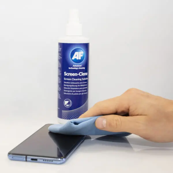 Eine Hand hält eine Flasche Screen-Clene – Universal Screen Cleaning Pump Spray – 250 ml SCS250 auf einem Mobiltelefon.