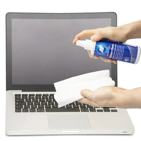 Une personne nettoyant un ordinateur portable avec Screen-Clene - Spray universel à pompe de nettoyage d'écran - 250 ml SCS250.