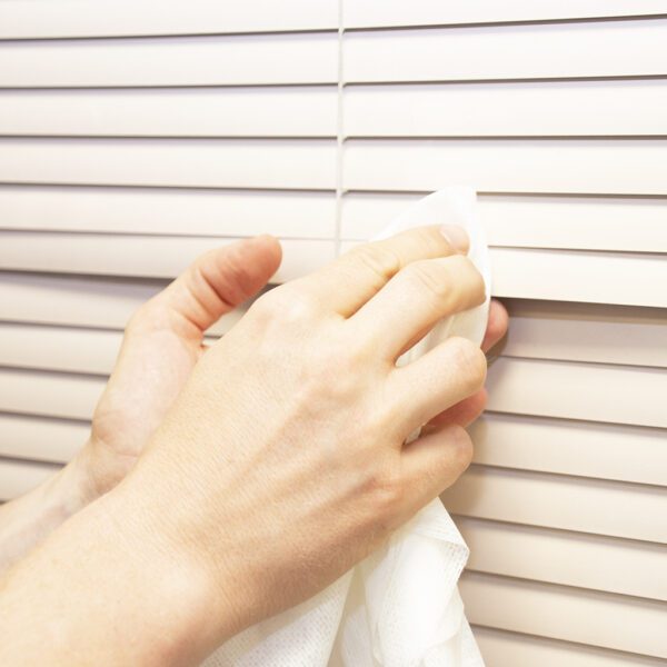 A person cleaning blinds with Magic Tack Duster Cloths - x25 MTD025P.