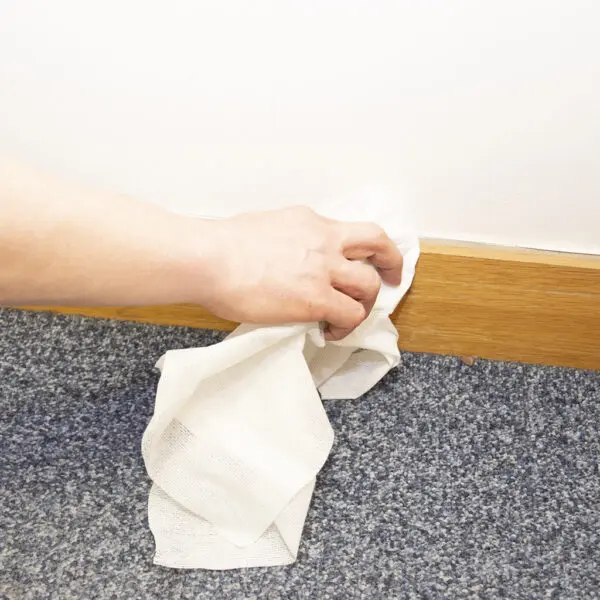 A person putting Magic Tack Duster Cloths - x25 MTD025P on the floor of a room.