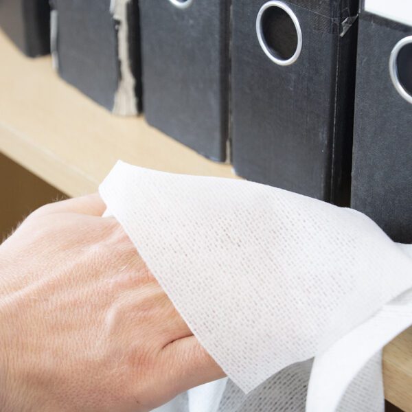 A hand is holding a Magic Tack Duster Cloths - x25 MTD025P on a shelf.