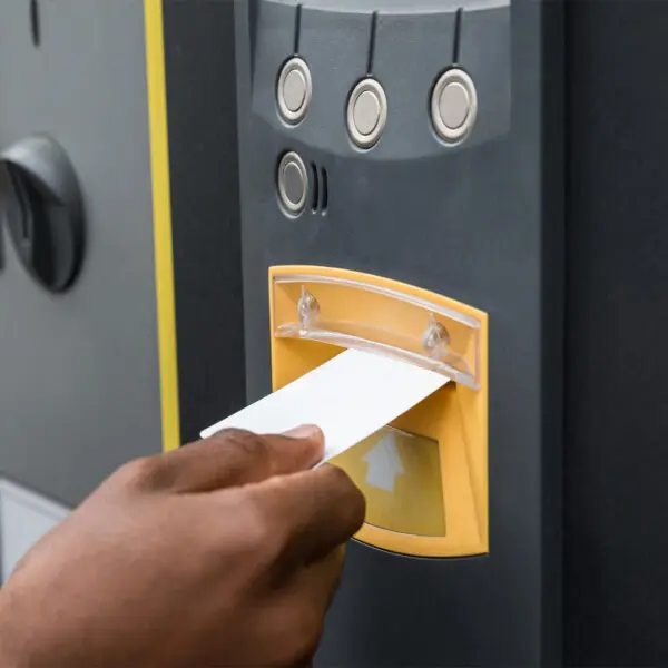 Eine Person, die eine Cardclene – Reinigungskarten für Magnetkopf-Kartenleser – x20 CCP020 in einen Automaten einführt.
