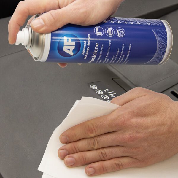 Eine Person sprüht eine Dose Maxiclene – Super Strength Foam Cleaner – 400 ml MXL400 auf ein Blatt Papier.