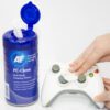 Hand cleaning a white game controller with wipes.