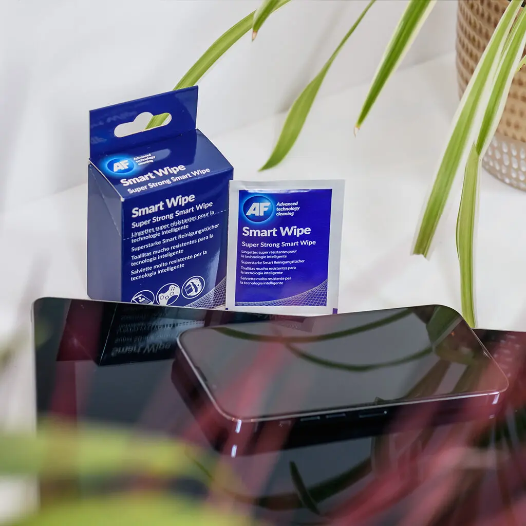 A package of Smart Wipes - Reusable Dry Lens and Screen Cleaning Wipe - x10 SMARTWIPE10 sitting on a table next to a plant.