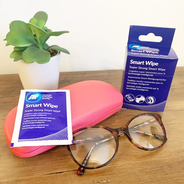 Eine Brille und eine Packung Smart Wipes – wiederverwendbare trockene Linsen- und Bildschirmreinigungstücher – x10 SMARTWIPE10 auf einem Tisch.
