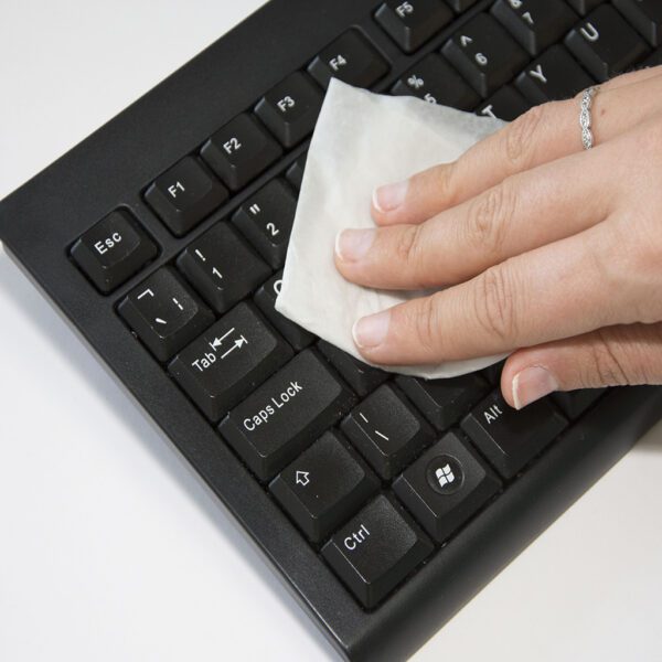 Eine Hand wischt eine Tastatur mit Utility-Bildschirm-/Mehrzweck-Reinigungstüchern ab – x100 SMPW100TUT.